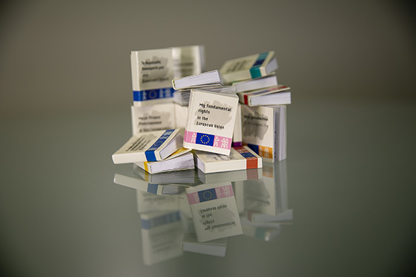 Stack of mini books of EU Charter of Fundamental Rights in different EU languages