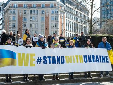People demonstrating with Stand with Ukraine banner