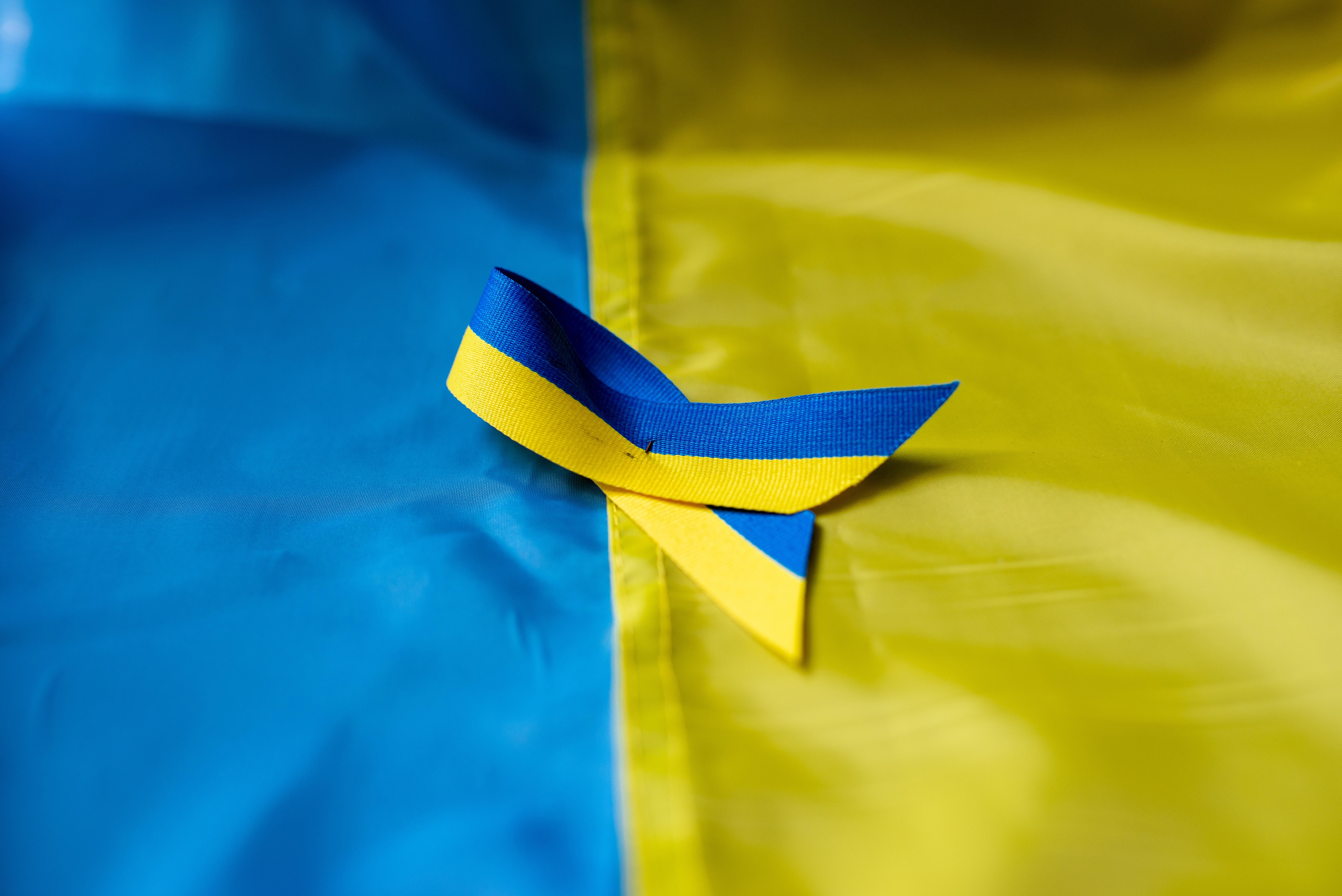 Ukrainian flag with ribbon of solidarity.