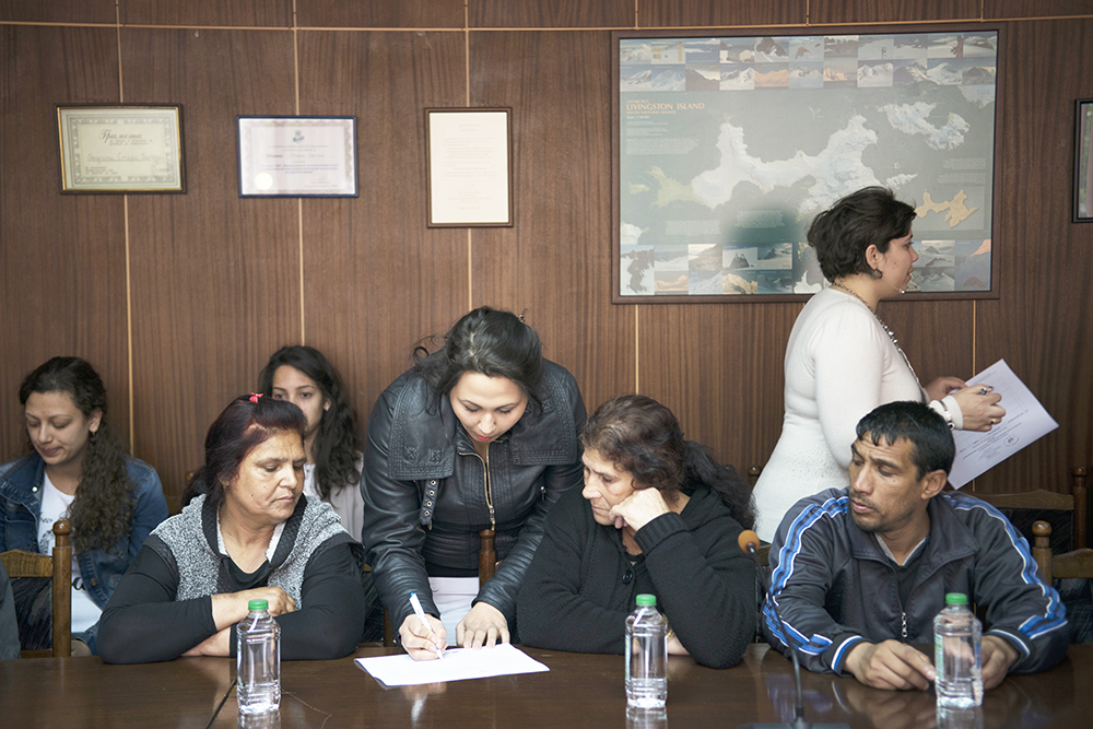 Group of Roma from Stara Zagora in a meeting room signing a document