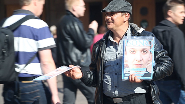 Roma man selling a street paper in Helsinki, Finland