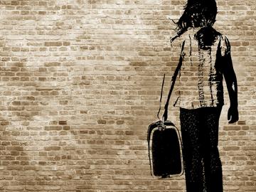 Graffiti/shadow on a brickwall showing a refugee girl walking with her suitcase
