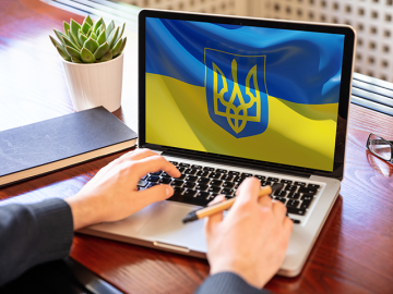 Support Ukraine, donate help Ukrainian people. Flag on computer laptop screen.