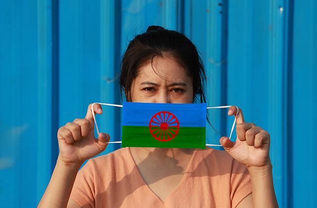 Roma woman with a facemask with a Roma flag on it