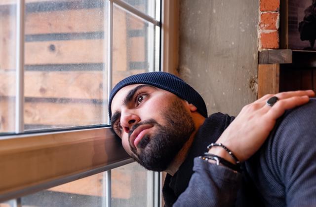 Sad muslim man looking out of a window